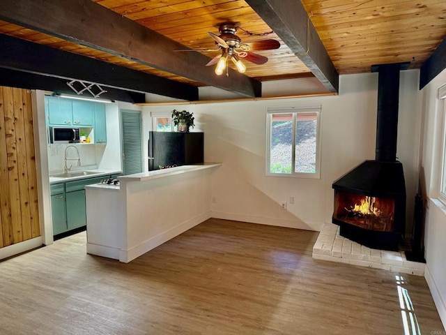 21803 Crestline Rd, Palomar Mountain, CA 92060 - kitchen featuring freestanding refrigerator, stainless steel microwave, a sink, wood ceiling with exposed beams, and light wood-style floors