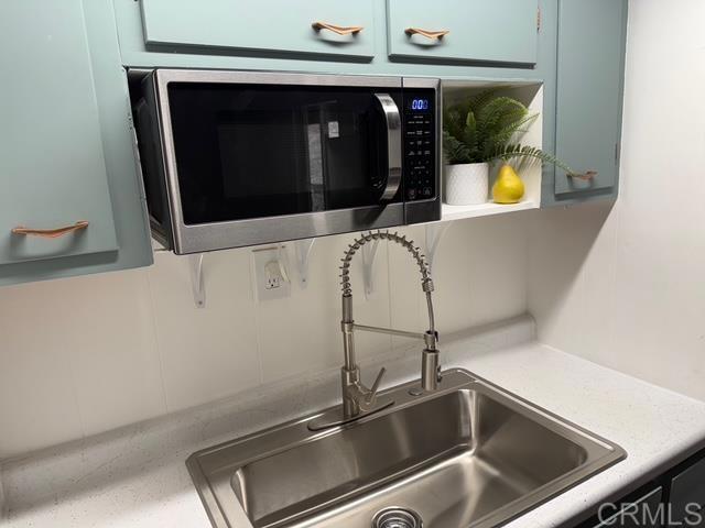 21803 Crestline Rd, Palomar Mountain, CA 92060 - kitchen view of stainless steel microwave, blue cabinetry, and light countertops
