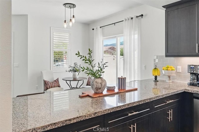 3981 Savannah Ln, Piru, CA 93040 - kitchen featuring light stone counters, tasteful backsplash, pendant lighting, and dark cabinetry