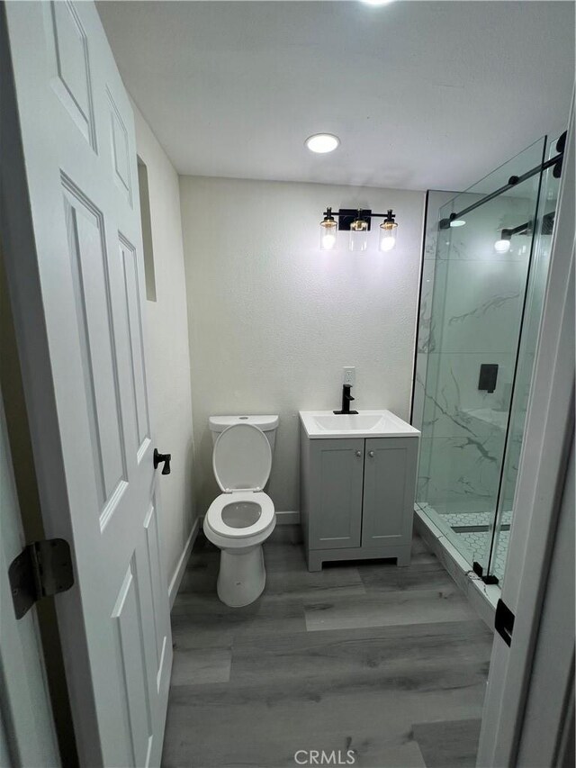 14726 Osage Rd, Apple Valley, CA 92307 - bathroom featuring a marble finish shower, wood finished floors, vanity, and recessed lighting