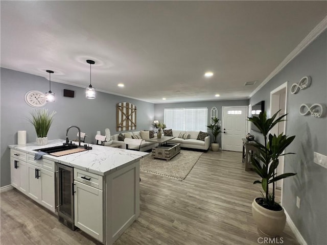 14726 Osage Rd, Apple Valley, CA 92307 - kitchen with beverage cooler, wood finished floors, white cabinets, recessed lighting, and ornamental molding