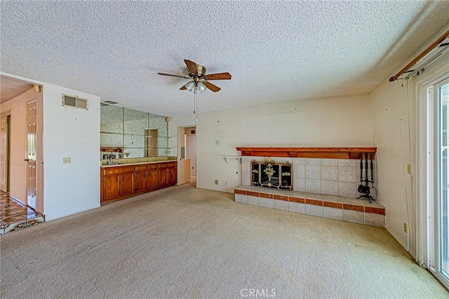 1736 Island Dr, Fullerton, CA 92833 - unfurnished living room featuring a tiled fireplace, a textured ceiling, ceiling fan, light carpet, and a sink
