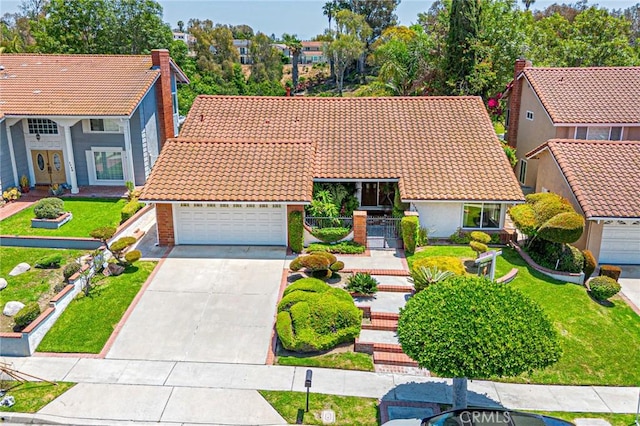 1736 Island Dr, Fullerton, CA 92833 - mediterranean / spanish-style house featuring a tiled roof, driveway, a front lawn, a residential view, and brick siding