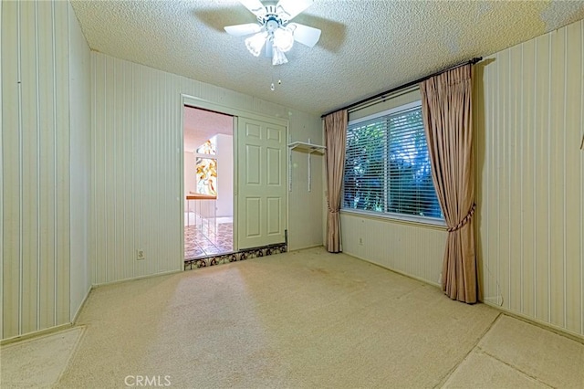 1736 Island Dr, Fullerton, CA 92833 - spare room with a textured ceiling, carpet, ceiling fan, and wooden walls