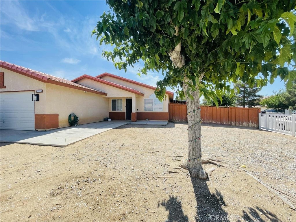 14462 Ivy St, Adelanto, CA 92301 - rear view of property featuring stucco siding and a tiled roof