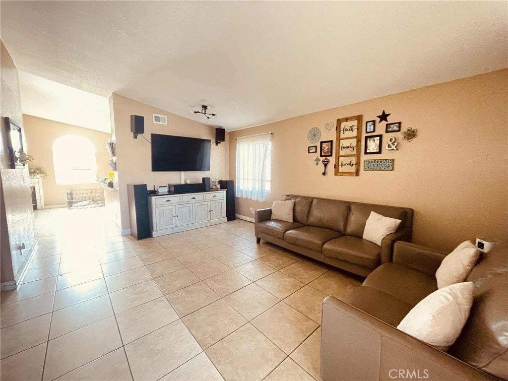 14462 Ivy St, Adelanto, CA 92301 - living room with vaulted ceiling and light tile patterned floors