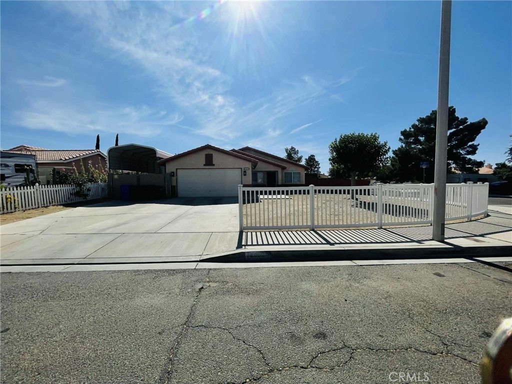 14462 Ivy St, Adelanto, CA 92301 - view of front facade featuring driveway and an attached garage