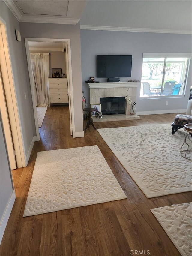 5461 W Palmer Dr, Banning, CA 92220 - living area with wood finished floors, baseboards, a tiled fireplace, and ornamental molding