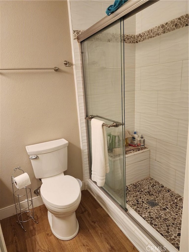 5461 W Palmer Dr, Banning, CA 92220 - full bathroom featuring wood finished floors, a stall shower, toilet, and baseboards