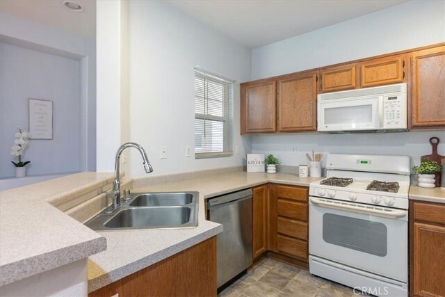 26426 Arboretum Way Unit 806, Murrieta, CA 92563 - kitchen featuring white appliances, brown cabinetry, a sink, light countertops, and a peninsula