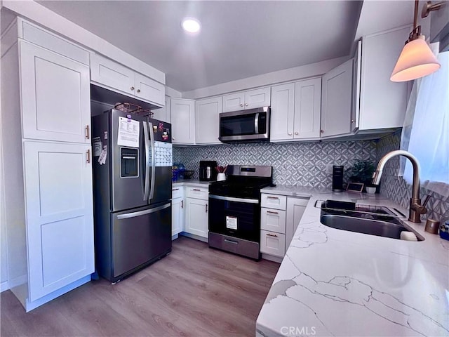 2969 Crestwood Pl, Riverside, CA 92503 - kitchen with appliances with stainless steel finishes, a sink, light stone countertops, decorative backsplash, and light wood-style floors