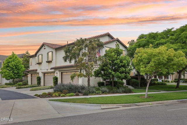 3224 Lisbon Ln, Oxnard, CA 93036 - mediterranean / spanish house with an attached garage, stucco siding, a tile roof, driveway, and a front yard