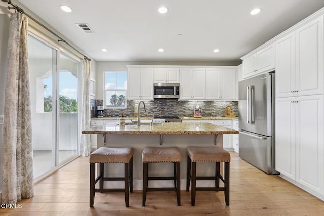 3224 Lisbon Ln, Oxnard, CA 93036 - kitchen featuring appliances with stainless steel finishes, tasteful backsplash, light stone counters, white cabinetry, and recessed lighting