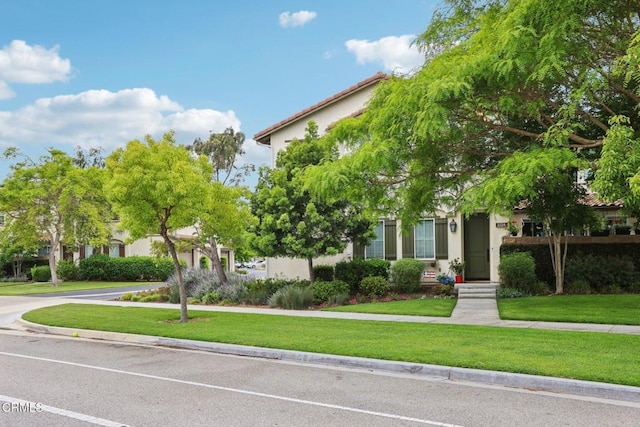 3224 Lisbon Ln, Oxnard, CA 93036 - view of property hidden behind natural elements with stucco siding, a front lawn, and a tile roof