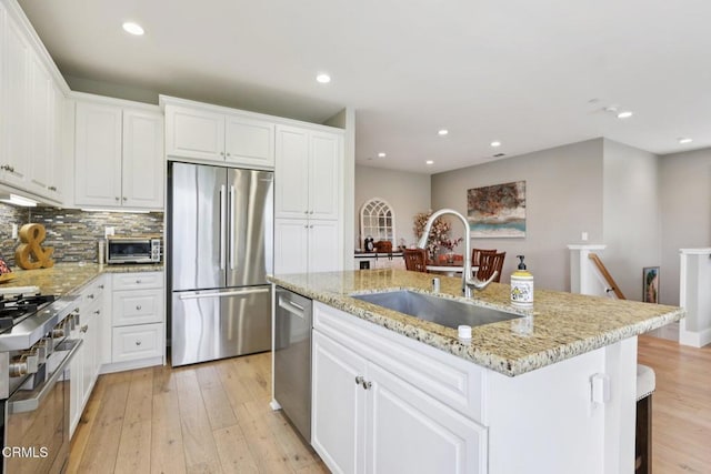 3224 Lisbon Ln, Oxnard, CA 93036 - kitchen featuring appliances with stainless steel finishes, a sink, light wood-type flooring, white cabinetry, and recessed lighting