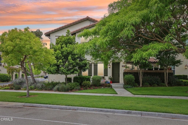 3224 Lisbon Ln, Oxnard, CA 93036 - obstructed view of property featuring a tiled roof, stucco siding, and a lawn