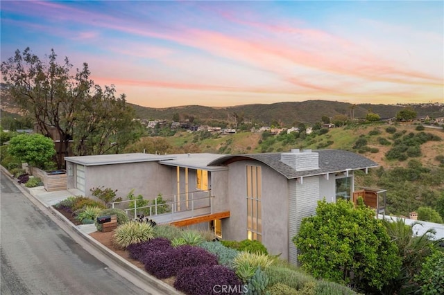 1385 Terrace Way, Laguna Beach, CA 92651 - view of front facade featuring a mountain view, a chimney, a shingled roof, a balcony, and a garage