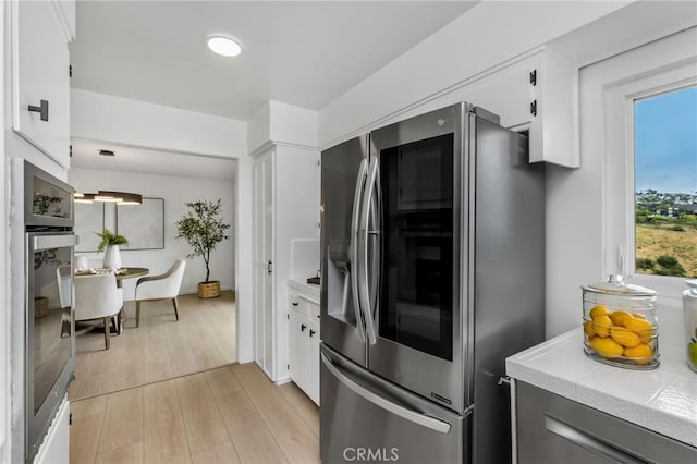 1385 Terrace Way, Laguna Beach, CA 92651 - kitchen featuring stainless steel appliances, tile countertops, white cabinetry, and light wood-style floors