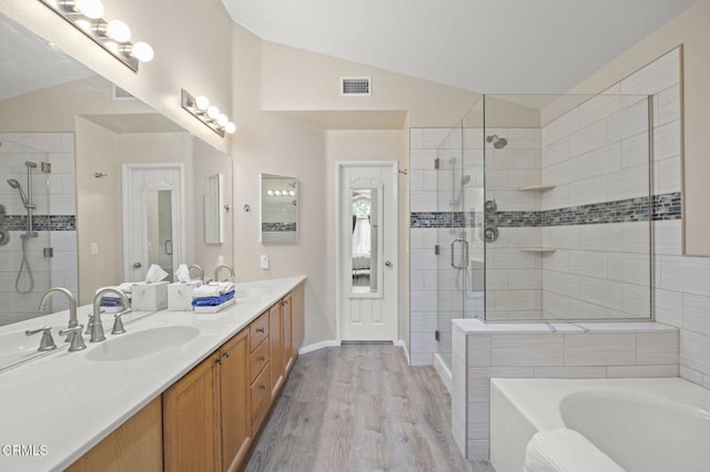 1323 Lost Point Ln, Oxnard, CA 93030 - bathroom with vaulted ceiling, double vanity, a shower stall, a bath, and wood finished floors
