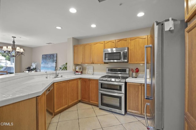 1323 Lost Point Ln, Oxnard, CA 93030 - kitchen with stainless steel appliances, light tile patterned floors, recessed lighting, a chandelier, and tile countertops