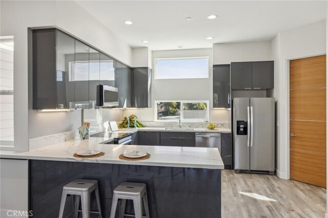 453 N 13th St, Grover Beach, CA 93433 - kitchen featuring appliances with stainless steel finishes, gray cabinetry, modern cabinets, a peninsula, and light wood-style floors