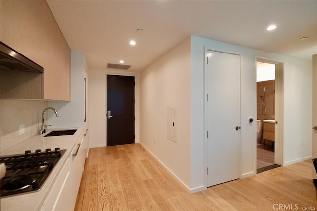 877 Francisco St Unit 1903, Los Angeles, CA 90017 - kitchen featuring a sink, stainless steel gas stovetop, light wood-style flooring, recessed lighting, and light countertops