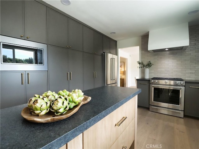 26633 Academy Dr, Palos Verdes Peninsula, CA 90274 - kitchen with appliances with stainless steel finishes, dark countertops, tasteful backsplash, light wood-style flooring, and custom exhaust hood