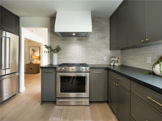 26633 Academy Dr, Palos Verdes Peninsula, CA 90274 - kitchen with stainless steel appliances, premium range hood, dark countertops, light wood-style flooring, and decorative backsplash