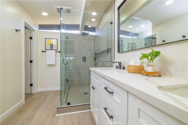 3567 Mount Everest Blvd, San Diego, CA 92111 - bathroom featuring double vanity, a shower stall, wood finished floors, and recessed lighting