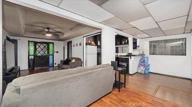 3902 Live Oak St, Cudahy, CA 90201 - living area featuring wood finished floors, a raised ceiling, and ceiling fan