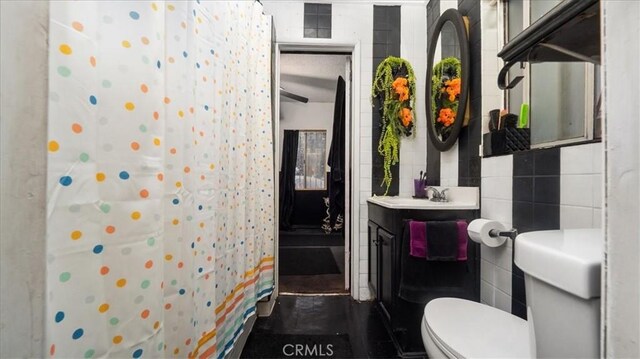 3902 Live Oak St, Cudahy, CA 90201 - full bathroom with toilet, vanity, a shower with curtain, and tile walls