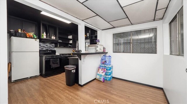 3902 Live Oak St, Cudahy, CA 90201 - kitchen featuring freestanding refrigerator, black gas range, dark cabinets, open shelves, and a drop ceiling
