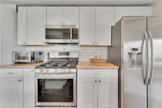 3074 Mountain Top Dr, Highland, CA 92346 - kitchen with stainless steel appliances, light countertops, white cabinets, and tasteful backsplash