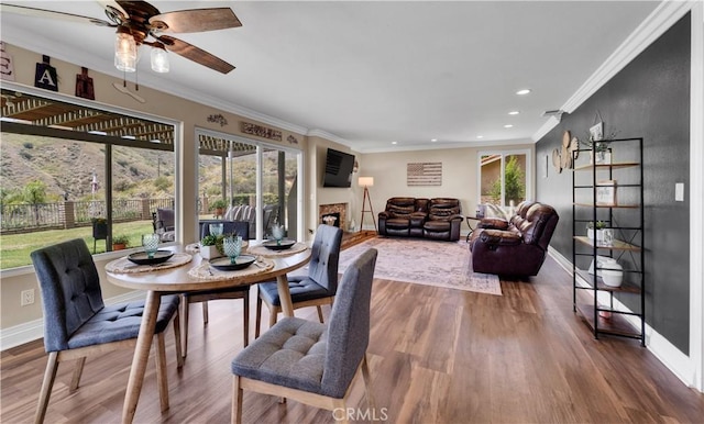 3074 Mountain Top Dr, Highland, CA 92346 - dining space with healthy amount of natural light, baseboards, crown molding, ceiling fan, and wood finished floors