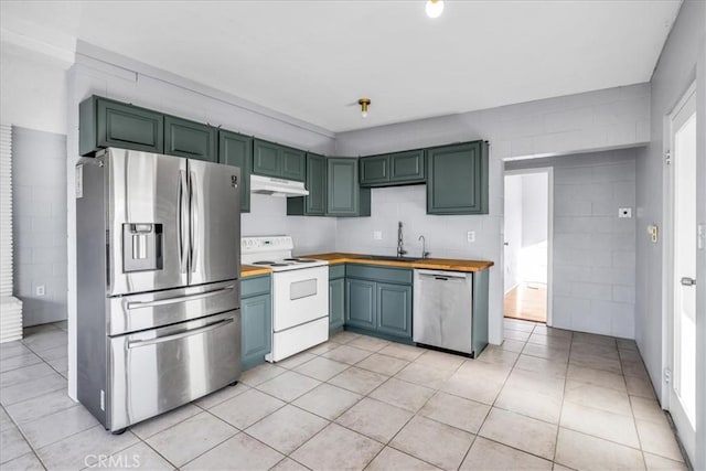 6646 Quail Spring Ave Unit 29, Palms, CA 92277 - kitchen with stainless steel appliances, a sink, under cabinet range hood, butcher block countertops, and light tile patterned floors