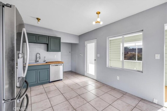 6646 Quail Spring Ave Unit 29, Palms, CA 92277 - kitchen with appliances with stainless steel finishes, a sink, butcher block countertops, and light tile patterned flooring