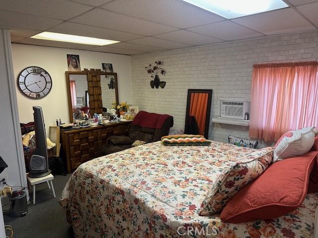 2440 Merrywood St, Pomona, CA 91767 - carpeted bedroom with a paneled ceiling and brick wall