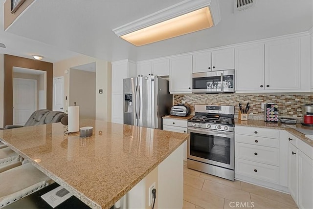 613 Flathead River St, Oxnard, CA 93036 - kitchen with stainless steel appliances, tasteful backsplash, white cabinetry, light tile patterned floors, and light stone counters