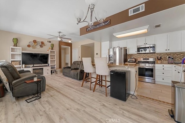 613 Flathead River St, Oxnard, CA 93036 - kitchen with appliances with stainless steel finishes, light wood-style flooring, open floor plan, and a breakfast bar