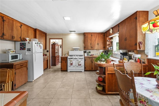 3095 Casitas Ave, Altadena, CA 91001 - kitchen with white appliances, open shelves, brown cabinetry, and healthy amount of natural light