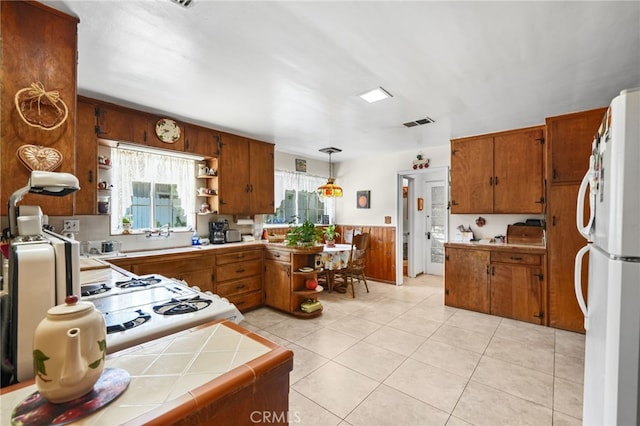 3095 Casitas Ave, Altadena, CA 91001 - kitchen with freestanding refrigerator, open shelves, brown cabinetry, and tile countertops