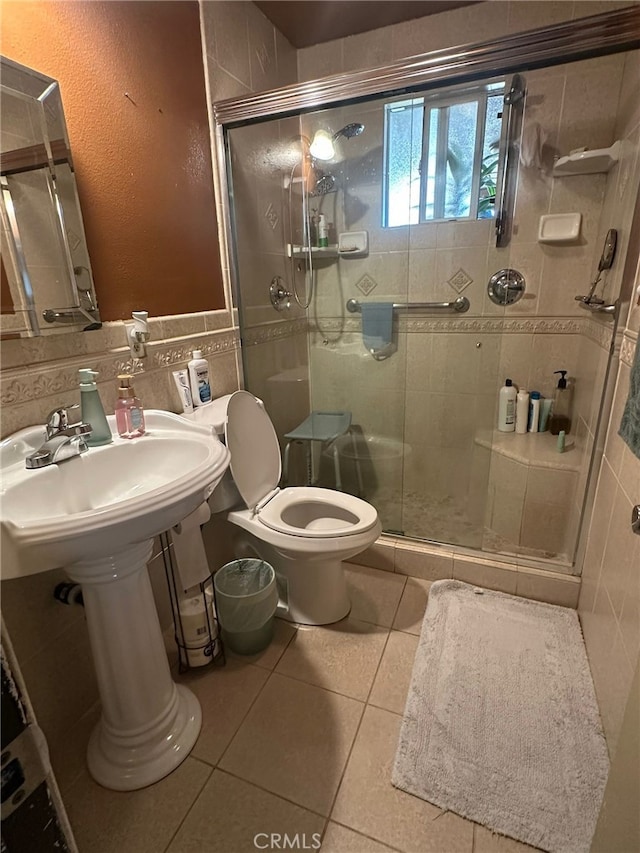 829 Foxworth Ave, La Puente, CA 91744 - bathroom featuring tile walls, tile patterned floors, a stall shower, and a wainscoted wall