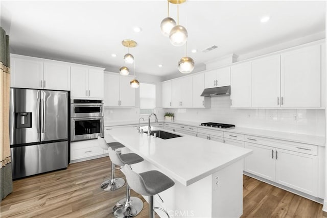 16526 Trailblazer Ave, Chino, CA 91708 - kitchen with appliances with stainless steel finishes, under cabinet range hood, light countertops, white cabinets, and recessed lighting