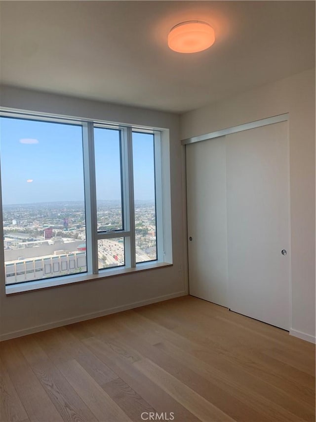 889 Francisco St Unit 2601, Los Angeles, CA 90017 - unfurnished bedroom with wood finished floors, a closet, and baseboards