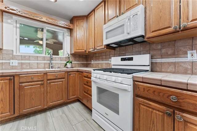433 E Mason St, Azusa, CA 91702 - kitchen with white appliances, tile counters, brown cabinetry, decorative backsplash, and a ceiling fan