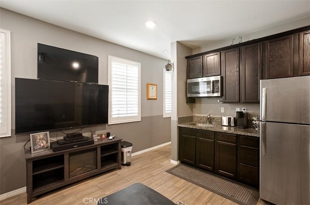 17995 Lacebark Ct, San Bernardino, CA 92407 - kitchen featuring appliances with stainless steel finishes, dark brown cabinetry, light wood-style floors, stone countertops, and recessed lighting