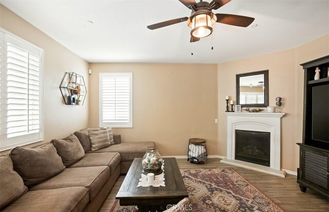 17995 Lacebark Ct, San Bernardino, CA 92407 - living room with wood finished floors, a glass covered fireplace, and a ceiling fan