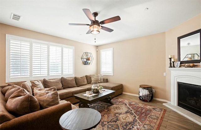 17995 Lacebark Ct, San Bernardino, CA 92407 - living area featuring ceiling fan, a glass covered fireplace, and wood finished floors