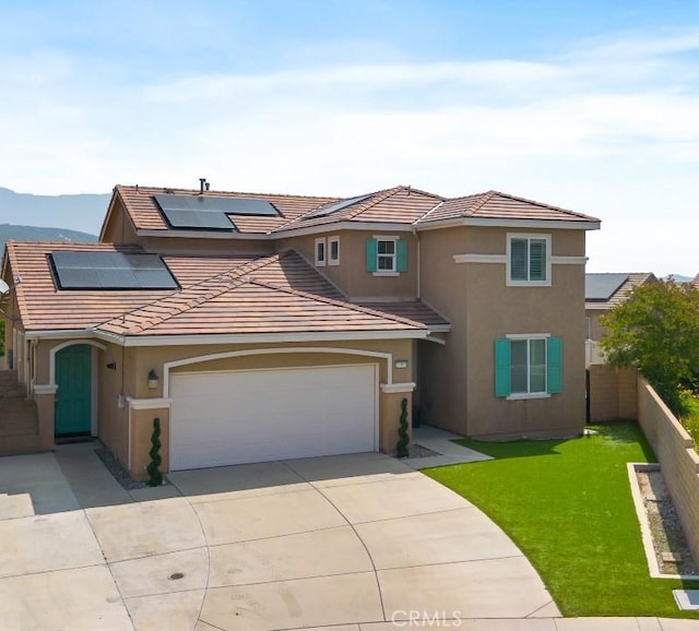 17995 Lacebark Ct, San Bernardino, CA 92407 - view of front of house featuring driveway, solar panels, a tile roof, and stucco siding