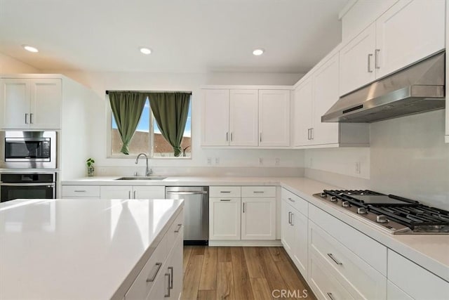 2750 182nd St Unit 112, Torrance, CA 90504 - kitchen with appliances with stainless steel finishes, under cabinet range hood, a sink, white cabinetry, and recessed lighting